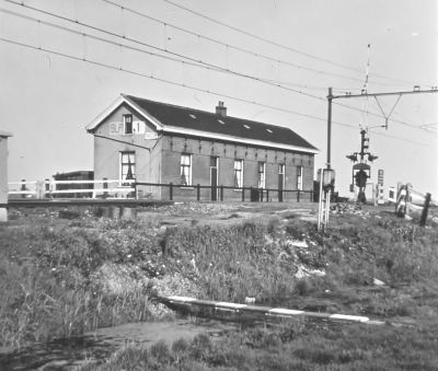 Spoorwachterswoning Blok 1, 
Bewoond door de familie Van Drie en J. Gentenaar. De spoorwegovergang werkt inmiddels automatisch.
