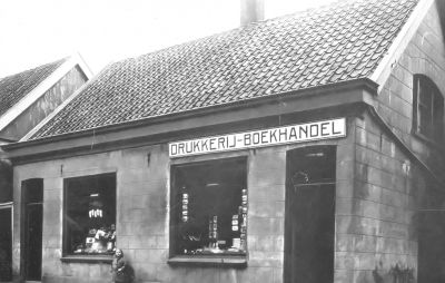 Op de hoek van de Ouderkerkerlaan tegenover de N.H kerk.
Vanaf 1921 drukkerij en boekhandel A.H de Wild, op de foto van 1926 staat Alie van Arnhem voor de sigarettenwinkel van W. Rijpkema.
