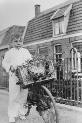 Voor het huis van J. Wessel,daarvoor J.Tas
Deze had een dochter Annie Tas die trouwde met J.Wessel Deze nam de zand-en grindhandel van zijn schoonvader over die aan de Stammerdijk was gevestigd. Na J.Tas kwam Th. Groenendaal uit het Gein er te wonen. Voor in beeld met versierde fiets Loekie Beekveld.
