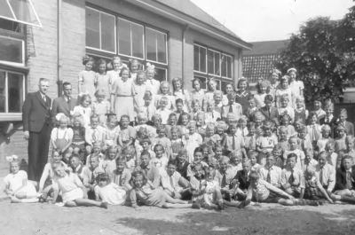 De heer L.F. de Weijs met de schoolfoto op het schoolplein met meester Leysen
