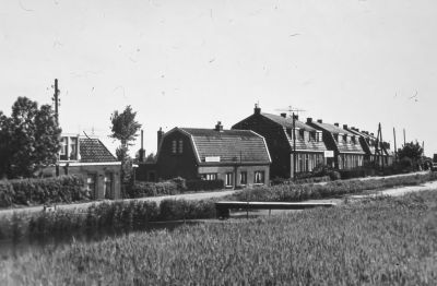 Woonhuis van de fam. Tishauser.
Woonhuis en winkel van de fam. Tishauser. met links op de voorgrond de woning van Jan Angel en het bruggetje naar de Prov.weg.

