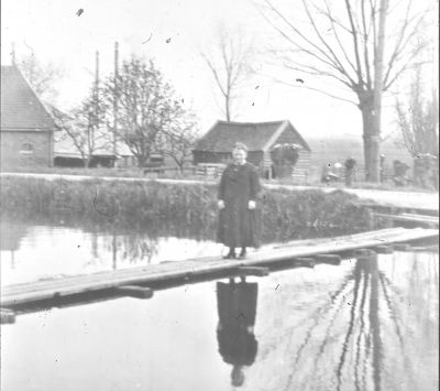 't Vlot in de Bijlmer ringsloot met Elisabeth Nagel
Dit vlot werd gebruikt om zaken als de melk en fietsen over te zetten. Later is er een bruggetje aangelegd. Op achtergrond boerderij  “Lammerenberg” van Pronk.
