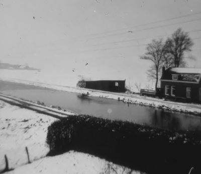 Dijkhuisje behorende bij de boerderij van Henk van Wijngaarden, gezien vanaf de molen van J. Griffioen
Het was vroeger de arbeiderswoning. Het werd bewoond door D.W van Wijngaarden. In de oorlog 1940-1945 door de fam. Boelekamp. Die moesten uit hun huis vanwege het water (inundatie) in de Oost Bijlmer. Daarna door de fam. Barte. Deze werkte als stamboekhouder bij de melkcontrole vereniging in Weesp. Daarna door Han van de Broek, getrouwd met Jans van Vegte. Han had een melk-en veetransport bedrijf.

