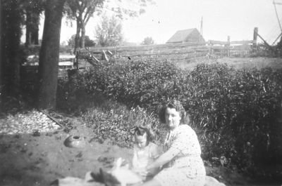 Mevrouw Boelekamp voor het dijkhuisje van van Wijngaarden (voorjaar 1945)
De oude molenschuur en een gedeelte van de molen zijn nog te zien.
