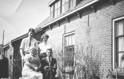 Achterkant woning C. van de Hulst. 
Vader en moeder C. van de Hulst, oudste zoon Piet en dochter Riet.
