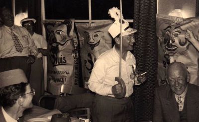 P. Sluis, fabriek pluimvee-, vee- en vogelvoeder 
Wie dit zijn is niet bekend, maar dat ze met Sluis te maken hebben is overduidelijk. De man in het witte overhemd heeft 'directie' op zijn feestpet staan (is hij een directie-lid?) en de drie 'zakken'/ 'pakken' (?) zijn erg carnavalesk...
Keywords: Geinbrug;Driemond;Sluis,pluimvee;vee;vogel;voeder