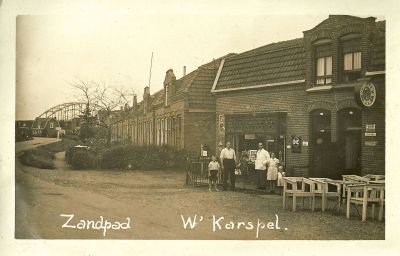 Kapper Zwart
Kapper Zwart voor zijn zaak. Rechts  ‘Kraantje Lek’. In de achtergrond de brug over het Merwedekanaal (latere Amsterdam Rijnkanaal).
Keywords: kapper;Zwart;Zandpad;Geinbrug;Driemond