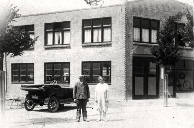 Mooiweer
Ab en Cornelia Mooiweer voor het nieuwe pand aan de Bletzstraat. Vermoedelijk is dit een uitbreiding/verhoging van het stenen pand op foto GOB035. Boven de ingang van de garage (dubbele deuren links) is de oude schuine constructie van het lagere pand nog te zien. Garagedeuren en deur van winkel en etalageraam zijn ook veranderd.
Keywords: Geinbrug;Driemond;Mooiweer;wagenmakerij;rijwielen;taxi