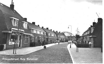 Burgemeester Bletzstraat
Burg. Bletzstraat. Links voor de kruidenierswinkel van Millenaar. Rechts dhr. Maarten de Rooij (met bretels). In de achtergrond de brug over het Merwede-/Amsterdam-Rijn kanaal. Foto ca. 1957.
Keywords: Burg.Bletzstraat;kruidenier;Millenaar;brug;Merwedekanaal;Amsterdam-Rijn kanaalWeesperkarspel