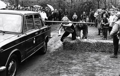 Koninginnedag, Oranjevereniging, auto duwen.
Met Koninginnedag was de Oranjevereniging actief organisator van allerlei feestelijkheden. Algemeen vermaak met springkussen en draaimolen voor kinderen en spelletjes al dan niet als wedstrijd voor oud en jong. 
Op de foto: auto duwen.
Keywords: Koninginnedag;Oranjevereniging;wedstrijd;vermaak;festiviteiten
