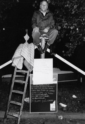 Koninginnedag, Oranjevereniging
Paalzitten. Op het zwarte bord worden bedragen aangegeven (van sponsors en weg te geven prijzen?) Op het bord staat ook de naam J.T. Scheltinga. Is dat de paalzitter?
Keywords: Koninginnedag;Oranjevereniging;wedstrijd;vermaak;festiviteiten